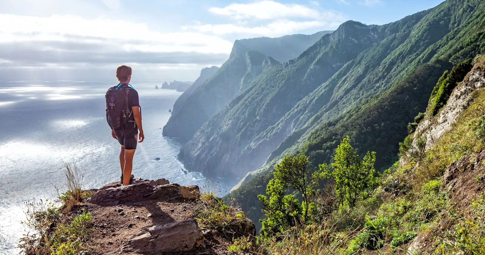 Hiker overlooking the coastal cliffs on Vereda do Larano